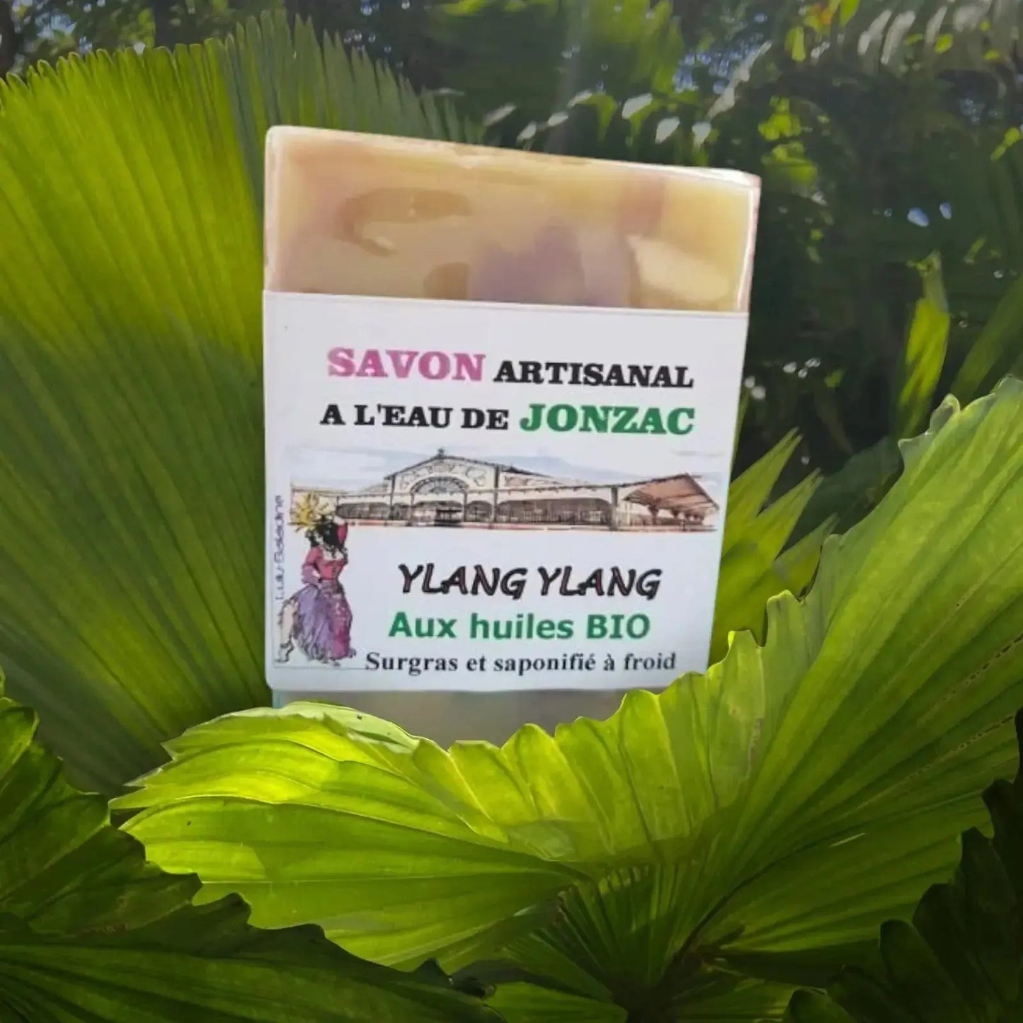 savon artisanal ylang ylang saponifié à froid à l’eau de Jonzac posé sur grandes feuilles tropicales