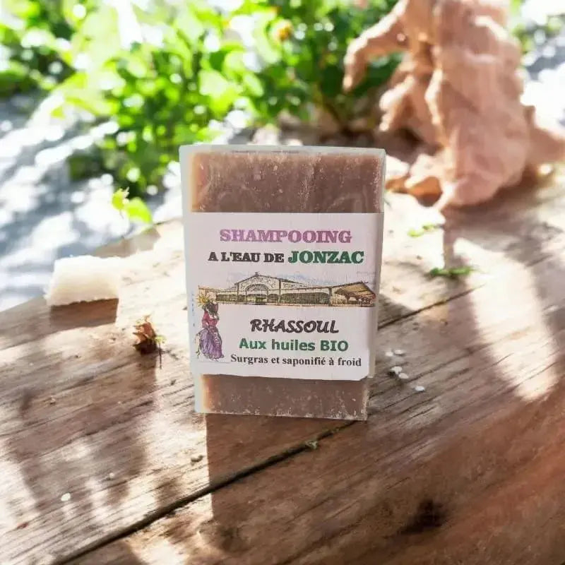 shampoing solide rhassoul saponifié à froid à l’eau de Jonzac posé sur planche bois avec lumière naturelle