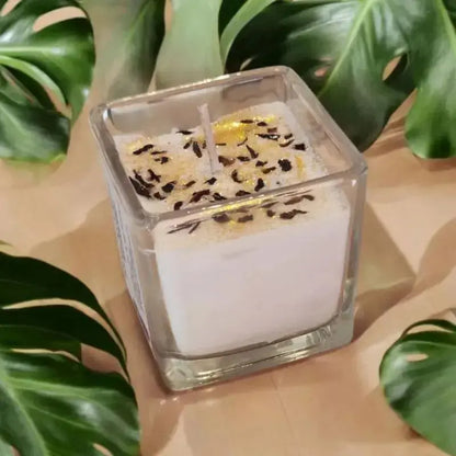 Bougie Carré poser sur une table avec des decoration divers et des paillette 