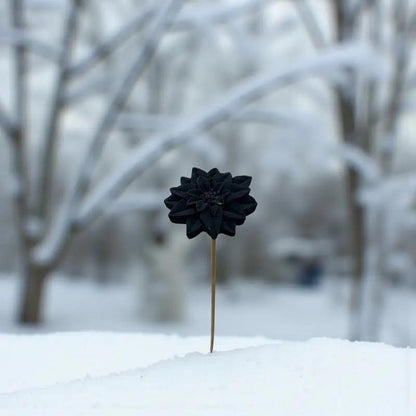 Étoile de Noël noire en cire artisanale, fleur décorative élégante dressée sur la neige en plein hiver – Lulu Baladine