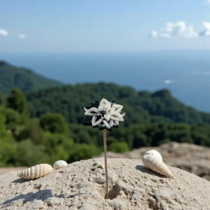 Étoile de Noël noire et blanche en cire artisanale, fleur décorative élégante sur fond de montagne et mer – Lulu Baladine