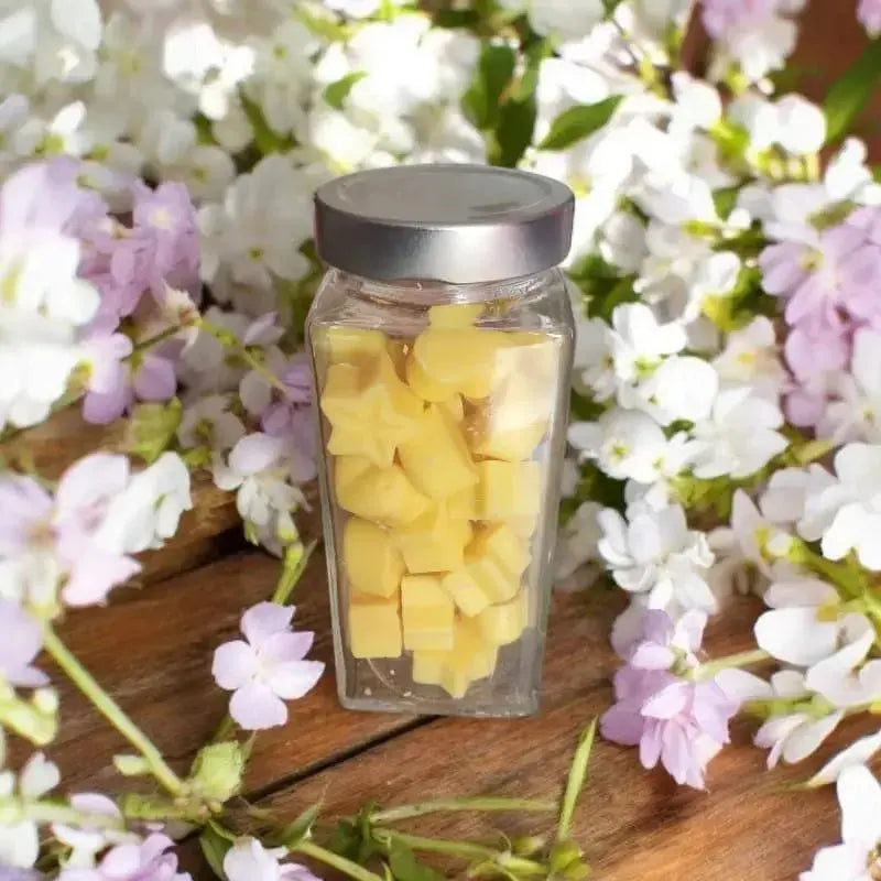 Fondant parfumé dans un bocal avec des fleur blanche de jasmin posée sur une table. Création artisanal Lulu Baladine