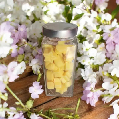 Fondant parfumé dans un bocal avec des fleur blanche de jasmin posée sur une table. Création artisanal Lulu Baladine