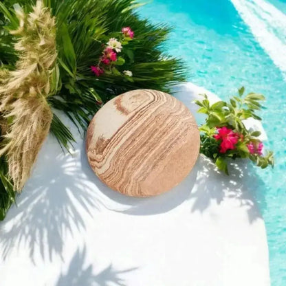 galet de massage et gommage siégeant sur une piscine bleu avec des fleurs en décors  