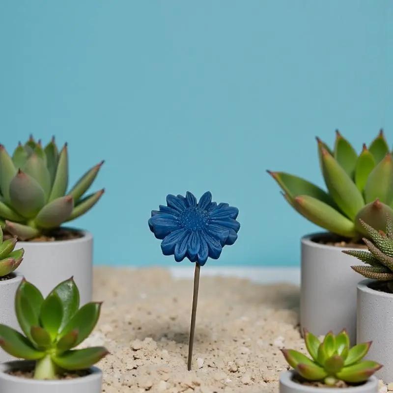 Gerbera bleu en cire artisanale, fleur décorative parmi des plantes succulentes – Lulu Baladine