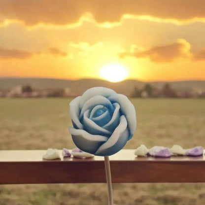 Petite rose bleue bordée de blanc en cire de soja naturelle devant un coucher de soleil — fleur parfumée artisanale à acheter, décoration poétique et cadeau symbolique.