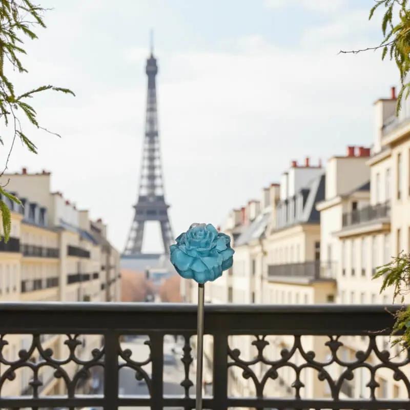 Petite fleur de cire œillet turquoise sur pont de paris minimaliste et lumineux avec tour Eiffel 