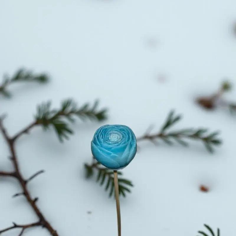 Petite renoncule Turquoise en cire artisanale, fleur poétique planté dans la neige, avec branches de sapin – Lulu Baladine