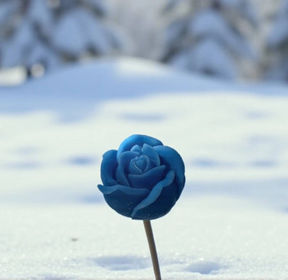 Petite rose bleue en cire de soja naturelle plantée dans la neige — fleur parfumée artisanale à acheter, décoration hivernale originale.