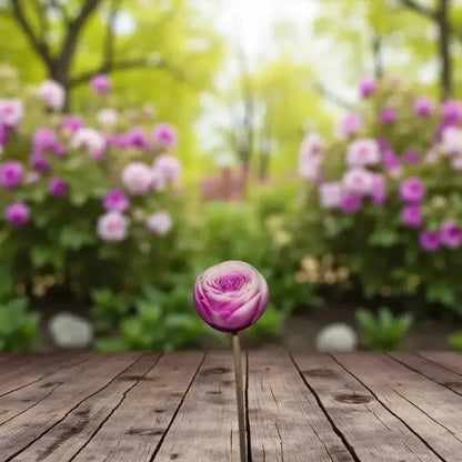 Petite renoncule bordée fushia en cire artisanale, fleur raffinée photographiée dans un jardin fleuri – Lulu Baladine