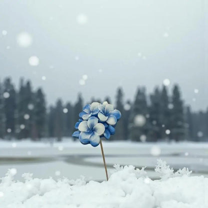 Primevère moyenne bordée bleue en cire artisanale, fleur décorative aux tons hivernaux reposant sur la neige – Lulu Baladine