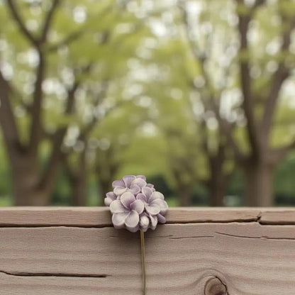 Primevère moyenne bordée vieux rose en cire artisanale, fleur décorative douce sur fond boisé printanier – Lulu Baladine