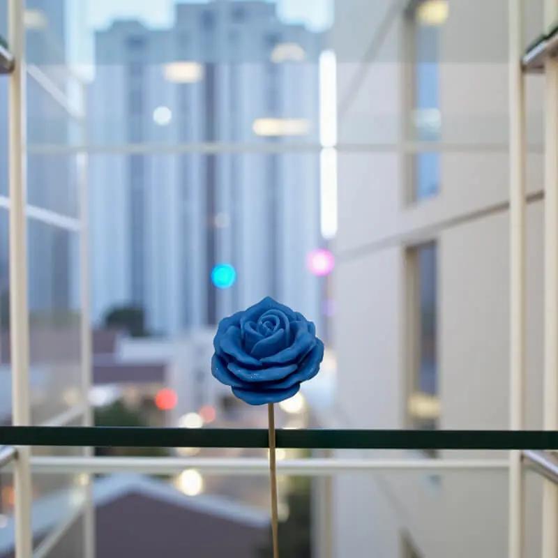 Rose moyenne bleue en cire artisanale, fleur décorative raffinée au cœur d’une ville moderne – Lulu Baladine