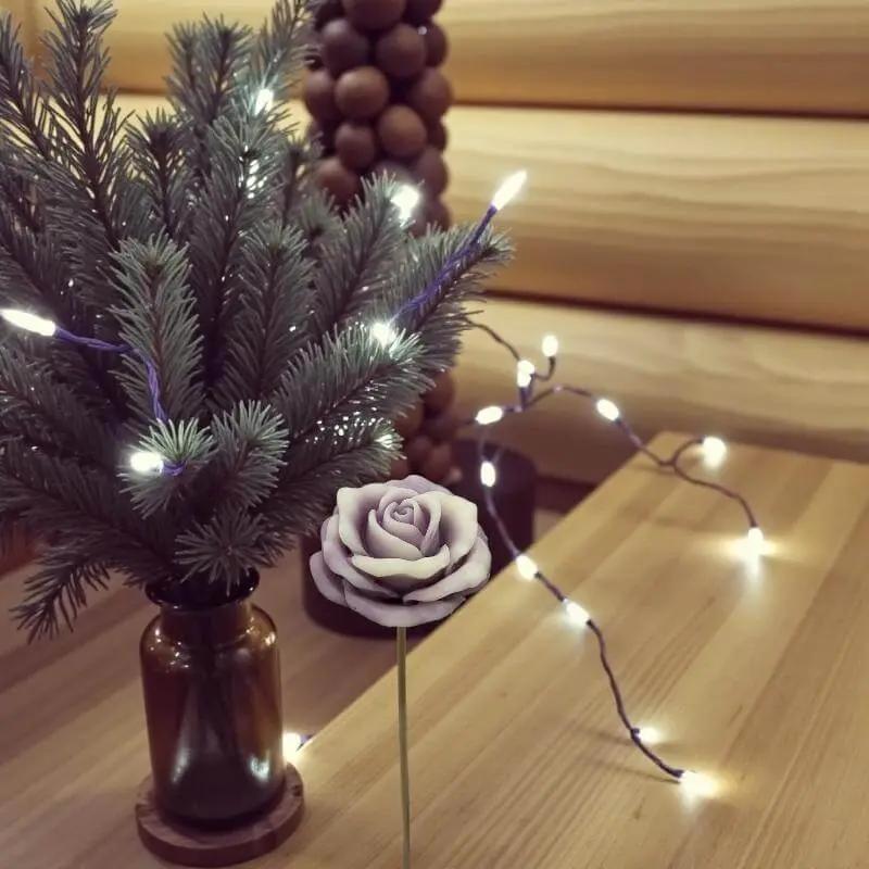 Rose moyenne bordée vieux rose en cire artisanale, fleur décorative élégante entourée de lumières festives – Lulu Baladine