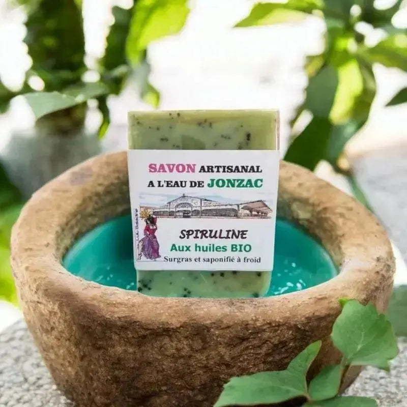 savon artisanal spiruline saponifié à froid à l’eau de Jonzac posé sur pierre avec eau turquoise