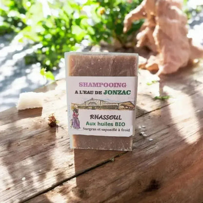 shampoing solide rhassoul saponifié à froid à l’eau de Jonzac posé sur planche bois avec lumière naturelle