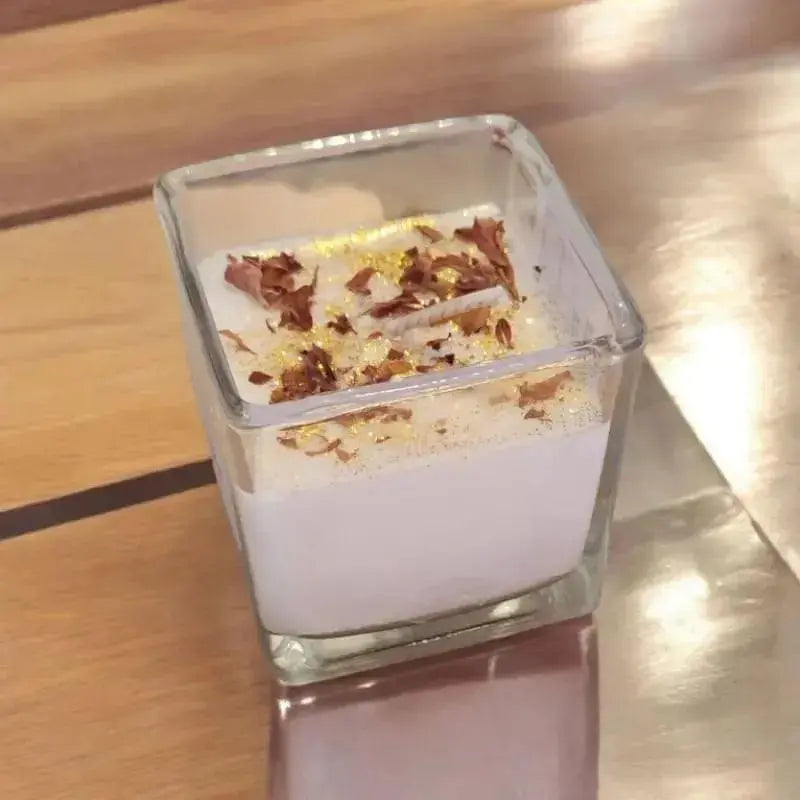 Bougie Carré poser sur une table avec des decoration divers et des paillette 