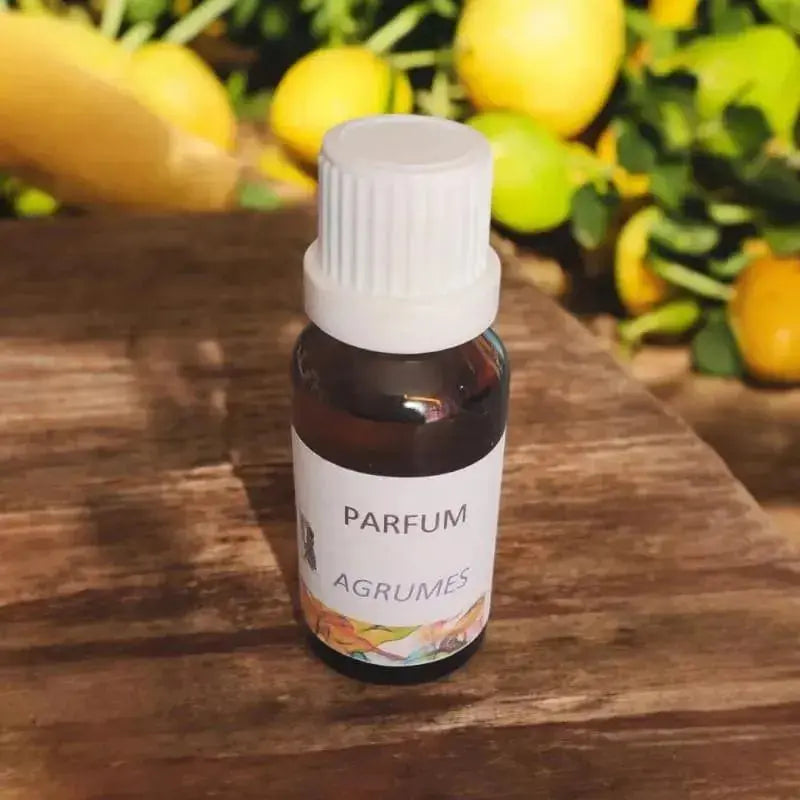 fiole ambrée d’extrait de parfum agrumes entourée de citrons, production artisanale de LuluBaladine